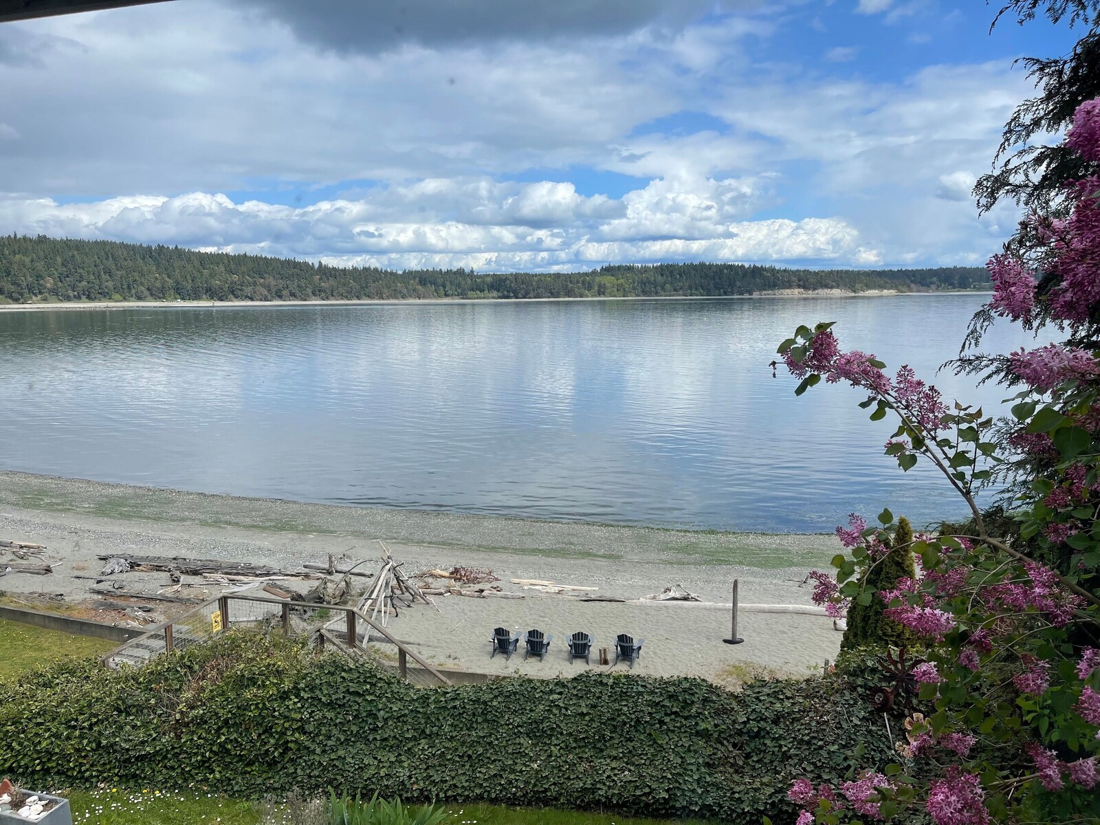 Sandy beach, deck, and chairs along Oak Bay