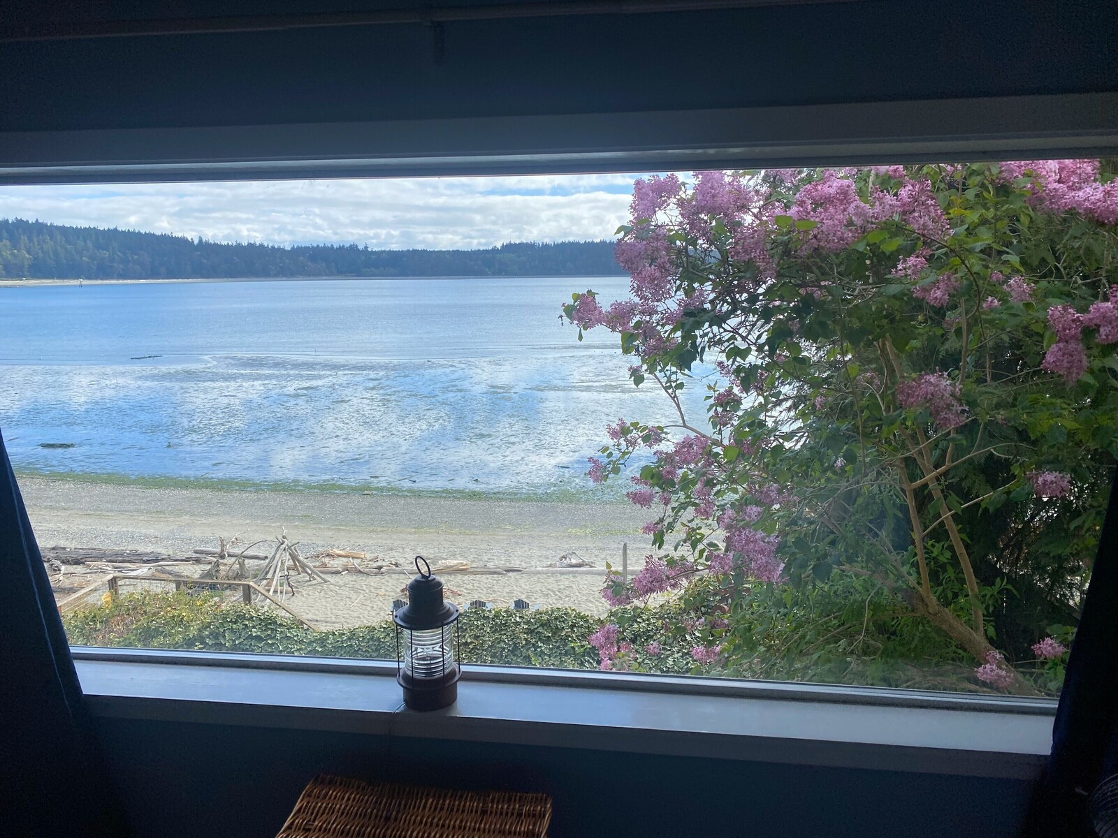 Bay view through a window with a lantern on the sill